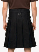 Person wearing a black pleated skirt with brown top on a white background