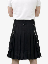 Person wearing a black pleated skirt with silver accents on a white background