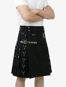 Person wearing a black kilt with silver hardware on a white background