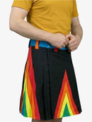 Person wearing a yellow shirt and a black kilt with rainbow stripes on a white background