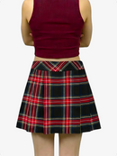 Person wearing a red plaid skirt and burgundy top on a white background