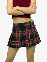 Person wearing a plaid skirt with a plain background