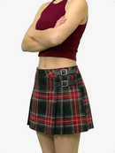Person wearing a red plaid skirt with black belt on a white background