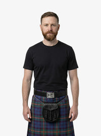 Man wearing a black t-shirt and plaid kilt on a white background
