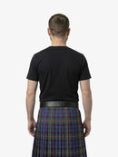 Man wearing a black t-shirt and a plaid kilt on a white background