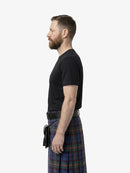 Man wearing a black t-shirt and plaid kilt on a white background