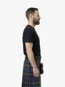 Man wearing a black t-shirt and plaid kilt on a white background