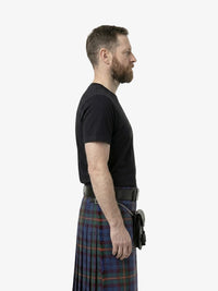 Man wearing a black t-shirt and plaid kilt on a white background