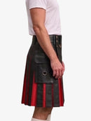 A man wearing a black leather kilt with red vertical stripes and a large front flap pocket, paired with a white t-shirt, shown from the side against a light gray background.