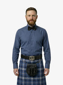 Man wearing a blue shirt, bow tie, and tartan kilt on a white background