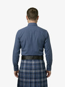 Man wearing a blue shirt and plaid kilt on a white background