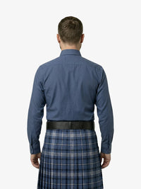 Man wearing a blue shirt and plaid kilt on a white background