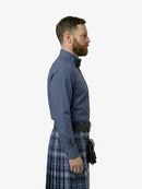 Man wearing a blue shirt and plaid kilt on a white background