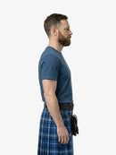 Man wearing a blue t-shirt and plaid kilt on a white background