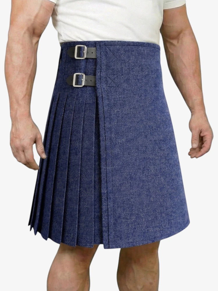 Person wearing a blue pleated kilt with a white background