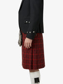 Person wearing a black jacket and red plaid kilt on a white background