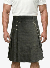 Person wearing a black kilt with silver buttons and chain on a white background