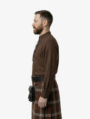 Man wearing a brown shirt and tartan kilt on a white background