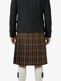 Person wearing a black jacket and brown plaid kilt on a white background