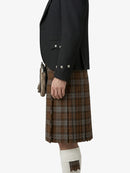 Person wearing a black jacket and brown plaid kilt on a white background