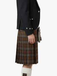 Person wearing a black jacket and brown plaid kilt on a white background
