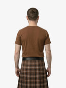 Man wearing a brown t-shirt and plaid kilt on a white background