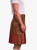 A man wearing a brown faux-leather kilt with pleated red and brown striped fabric panels, paired with a white t-shirt, shown from the side against a light gray background.