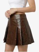 Brown leather skirt worn by a person on a white background