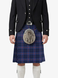 Person wearing a traditional Scottish kilt with a tartan pattern on a white background