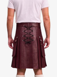 A person shown from the back wearing a pleated burgundy leather kilt with black lace-up detailing and silver-tone hardware, paired with a light pink t-shirt and white socks against a plain white background.