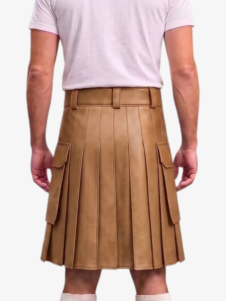 A person wearing a tan faux-leather pleated kilt with a matching belt and silver buckle, styled with a light pink t-shirt against a plain white background.