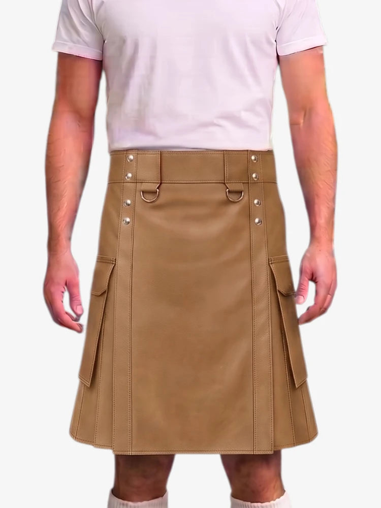 A person wearing a tan faux-leather kilt with silver-tone metal hardware and side cargo pockets, paired with a light pink t-shirt against a plain white background.