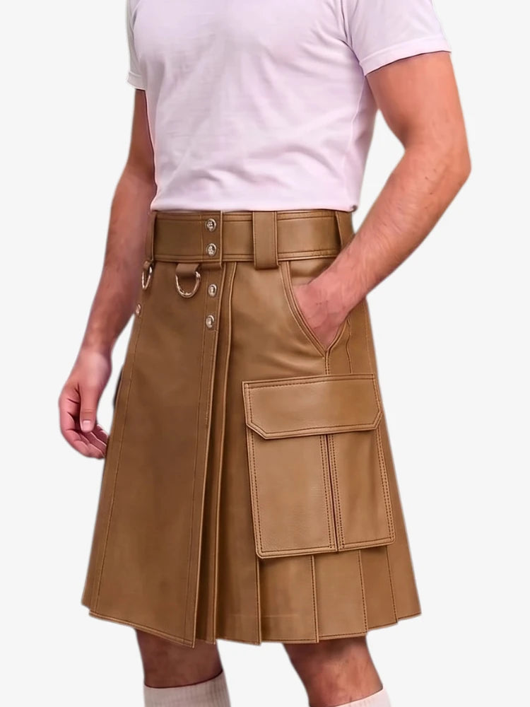 A person wearing a tan faux-leather pleated kilt with a matching belt and silver buckle, styled with a light pink t-shirt against a plain white background.