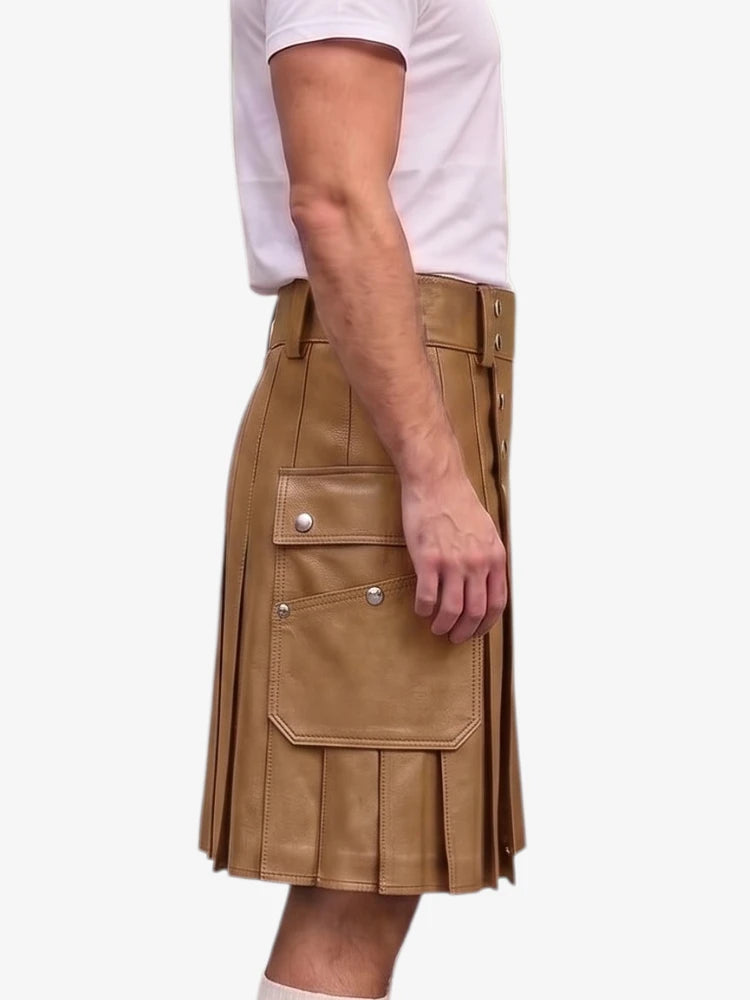 A side view of a person wearing a tan faux-leather kilt with pleats and cargo-style flap pockets, paired with a white t-shirt, against a plain light gray background.