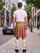 A man viewed from behind wearing a white t-shirt, a tan pleated leather kilt with red stripes, white knee-high socks, and black shoes, standing on a city sidewalk.