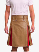 A man wearing a tan faux-leather kilt with red side panels and silver metal hardware, paired with a light pink t-shirt and white socks, against a plain white background.