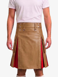 A man wearing a tan faux-leather kilt with red side panels and silver metal hardware, paired with a light pink t-shirt and white socks, against a plain white background.