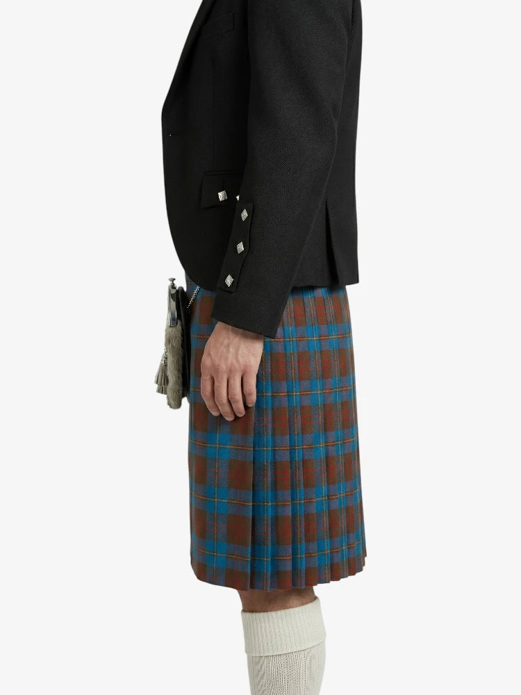 Person wearing a black jacket and plaid kilt on a white background