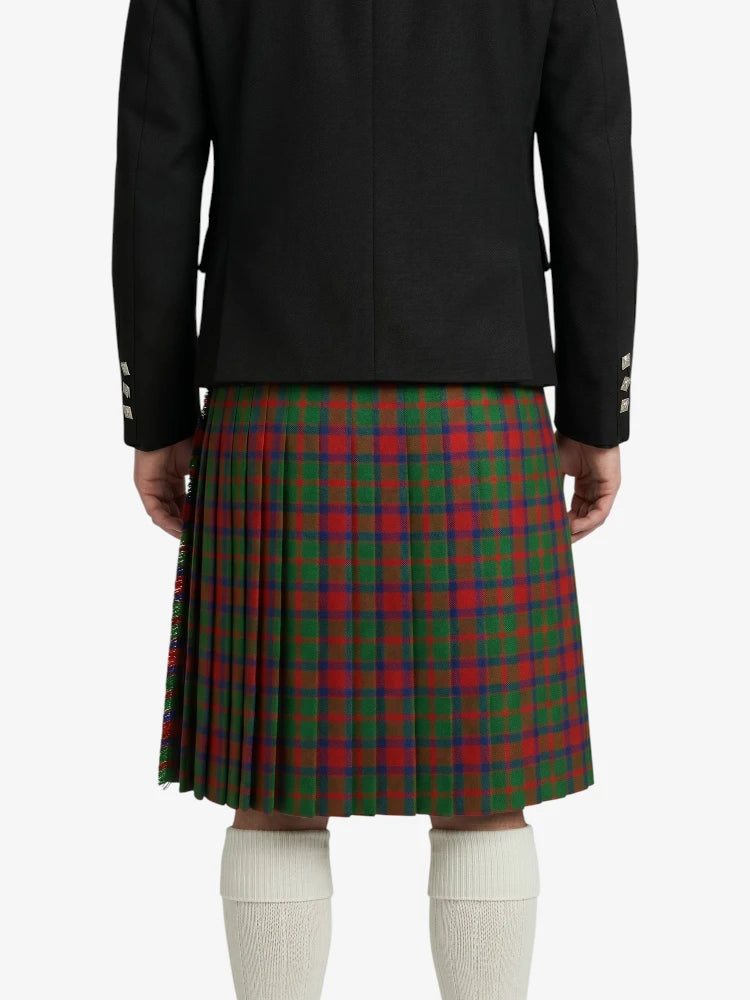 Person wearing a black jacket and red and green plaid kilt on a white background