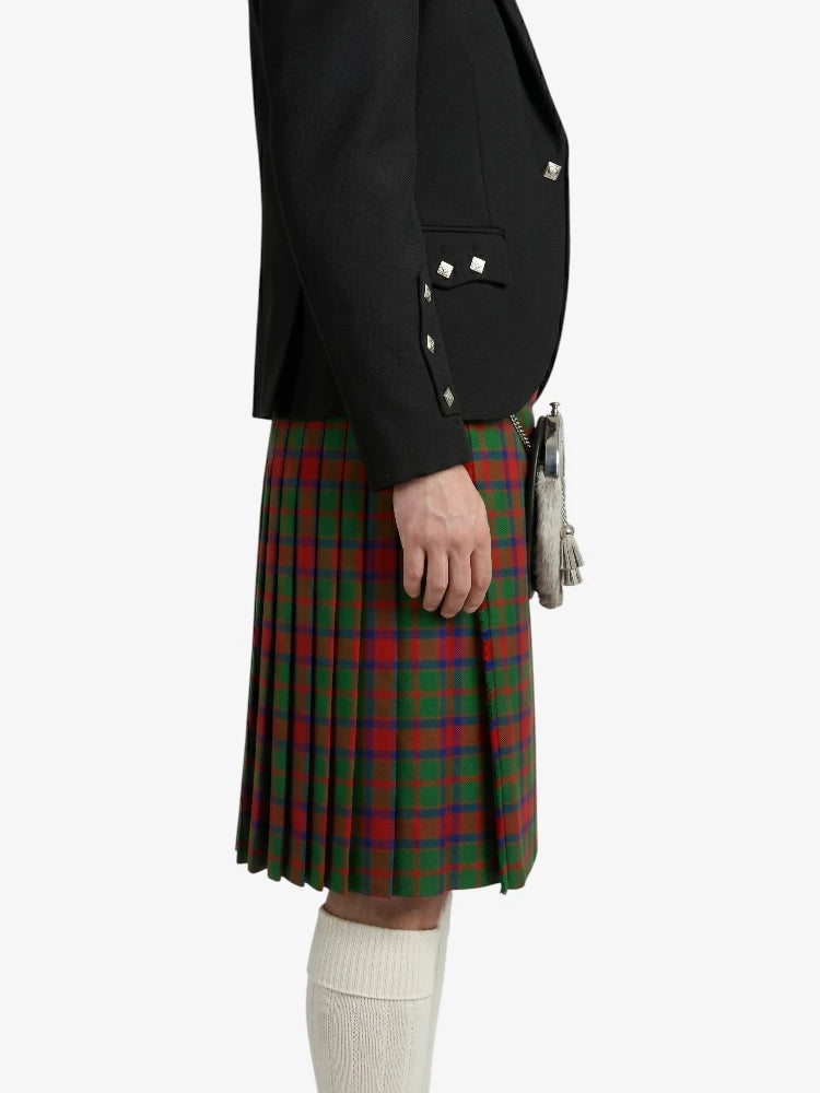 Person wearing a black jacket and red plaid kilt on a white background