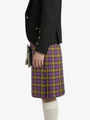 Person wearing a black blazer and plaid kilt on a white background