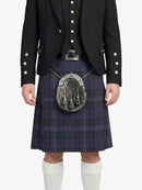 Person wearing a black jacket with white buttons, a blue plaid kilt, and white knee-high socks on a white background.