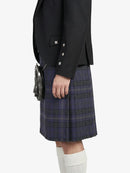 Person wearing a black jacket and plaid kilt on a white background
