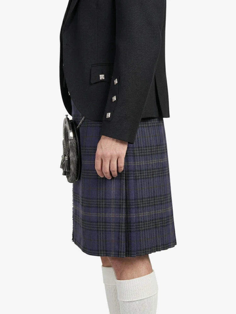 Person wearing a black jacket and plaid kilt on a white background