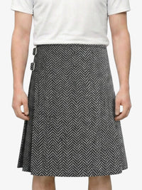 Person wearing a white shirt and black and white patterned skirt on a plain background