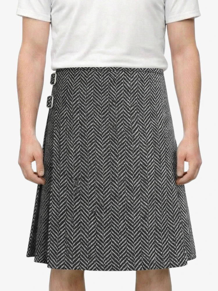 Person wearing a white shirt and black and white patterned skirt on a plain background