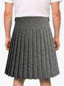 Person wearing a black and white pleated skirt on a white background