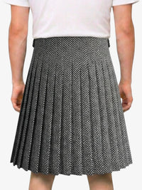 Person wearing a black and white pleated skirt on a white background