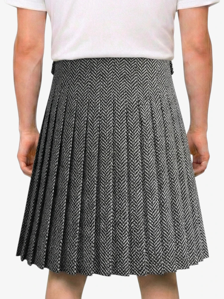Person wearing a black and white pleated skirt on a white background