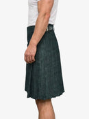 Person wearing a dark denim kilt on a white background